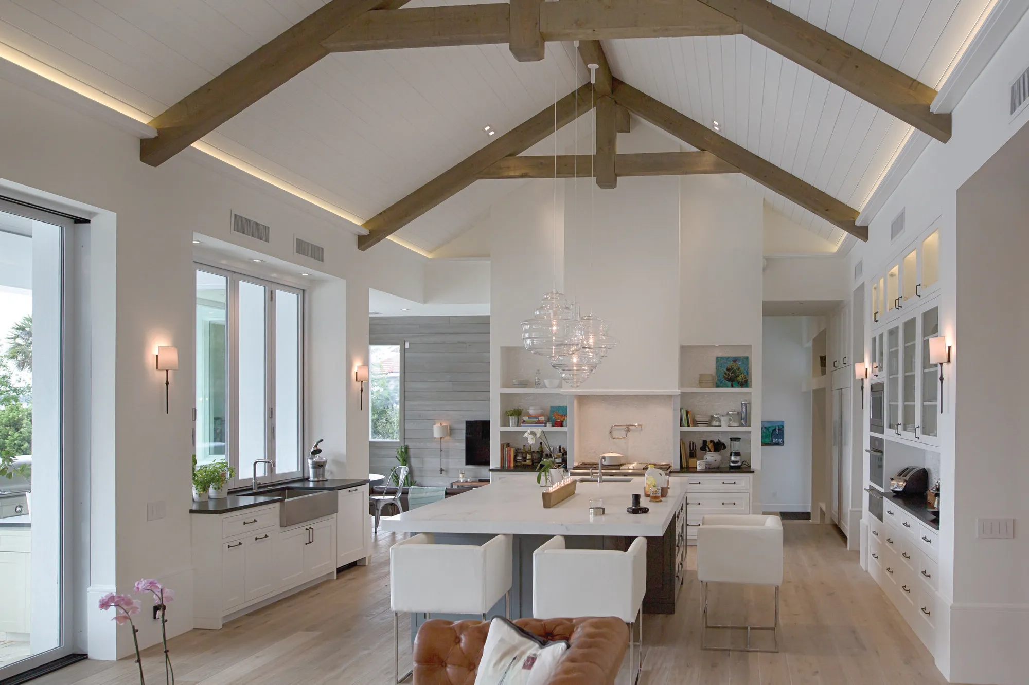 Vaulted-ceiling living space with layered pendant and sconce lighting